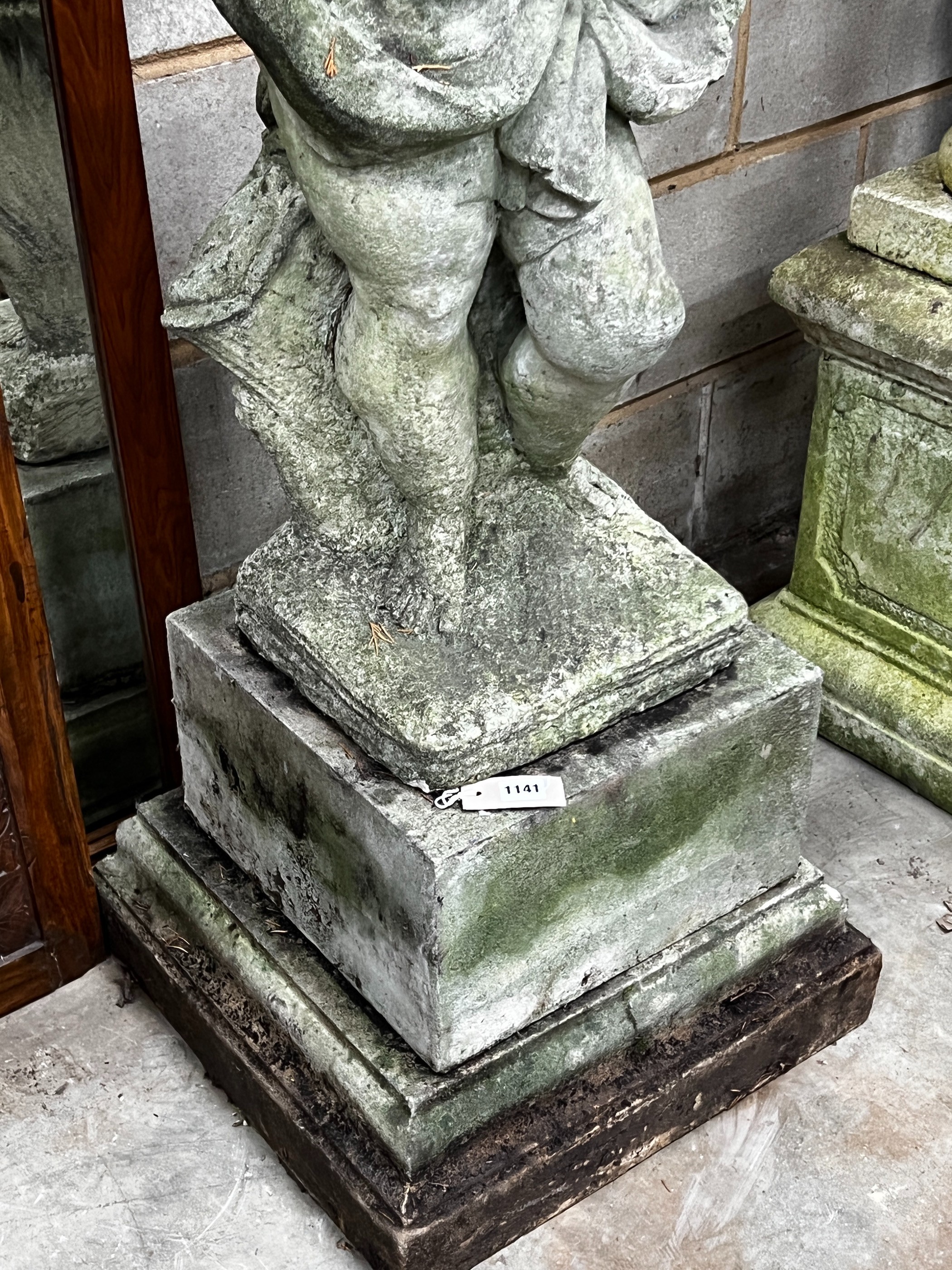 A large weathered reconstituted stone garden figure, cherub in drapery, height 122cm